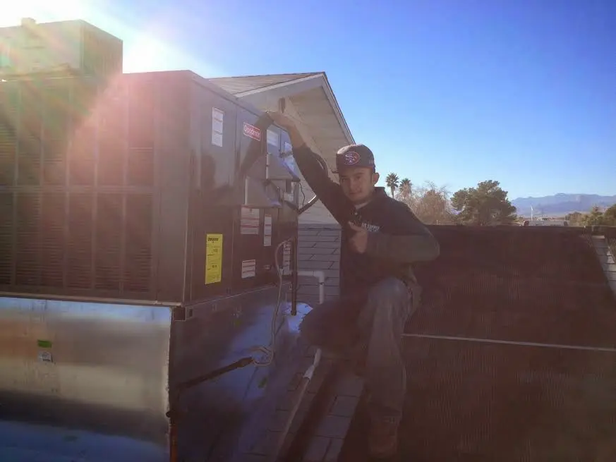 HVAC technician performing HVAC Inspection on a rooftop unit in Fair Lakes
